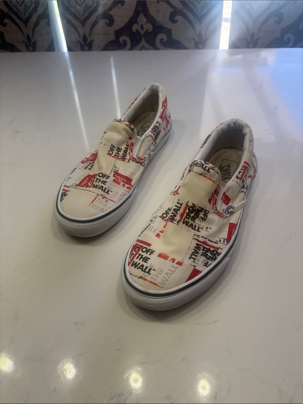 Vans Slip-On Sneakers in Cream with Red and Black Graphics
